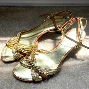 Gold sandals with heel and ankle strap.
